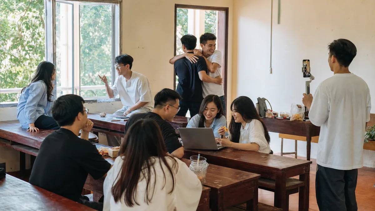 Nhóm alumni trẻ người Việt gặp lại, trò chuyện và dùng công nghệ trong lớp học cũ.